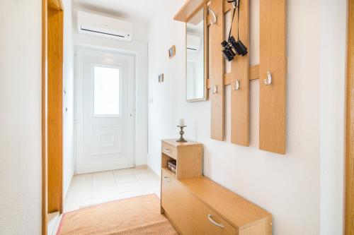 a hallway with a dresser and a white door at Apartment Arbanija 7543a in Trogir
