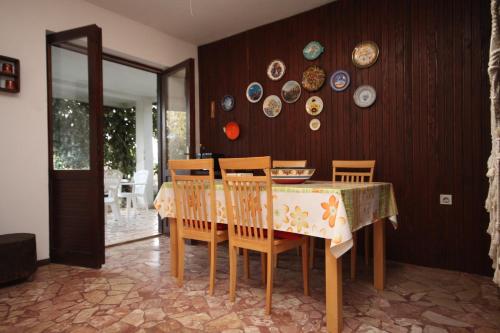 a dining room with a table and chairs and plates on the wall at Seaside holiday house Razanj, Rogoznica - 7514 in Rogoznica
