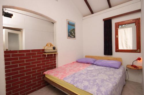 烏馬格的住宿－Seaside holiday house Umag - 7632，一间卧室设有一张床和砖墙