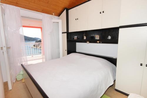 a bedroom with a white bed and a window at Apartments with a parking space Vela Luka, Korcula - 7551 in Vela Luka