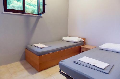 ein kleines Zimmer mit zwei Betten und einem Fenster in der Unterkunft Apartments with a parking space Podstrana, Split - 7572 in Podstrana