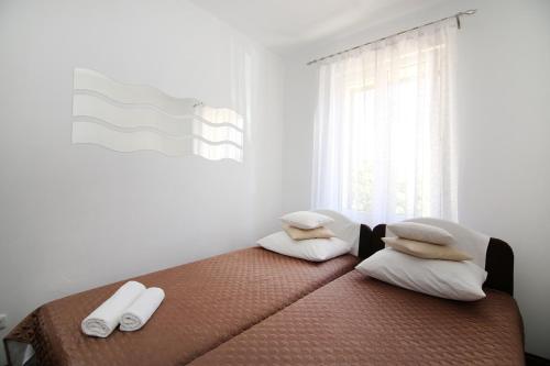 a bedroom with a bed with two pillows and a window at Apartments with a parking space Split - 7569 in Split