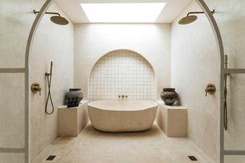 a bathroom with a bath tub and a window at Villa Lamer Canggu in Canggu