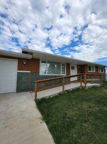 a house with a fence in front of it at Feel at home, Country style family house. in Magrath