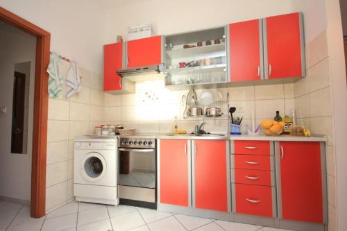 kuchnia z czerwonymi szafkami i pralką w obiekcie Apartments with WiFi Split - 7586 w Splicie
