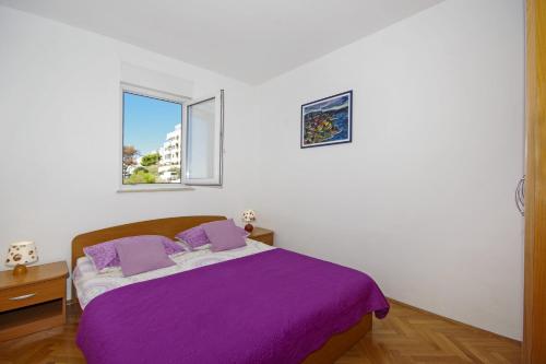 a bedroom with a purple bed and a window at Apartments by the sea Split - 7589 in Split