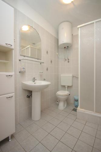 a bathroom with a sink and a toilet and a shower at Apartments by the sea Brna, Korcula - 7553 in Smokvica