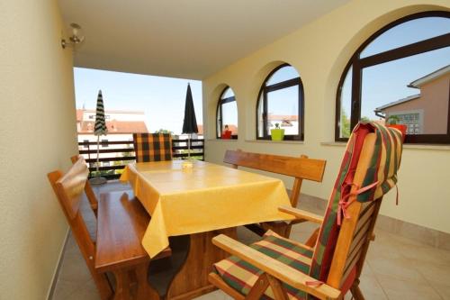 a dining room with a table and chairs and windows at Apartments with a parking space Peroj, Fazana - 7516 in Vodnjan