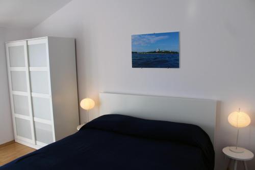 a bedroom with a bed and two lamps in it at Apartments with a parking space Vodice - 7604 in Vodice