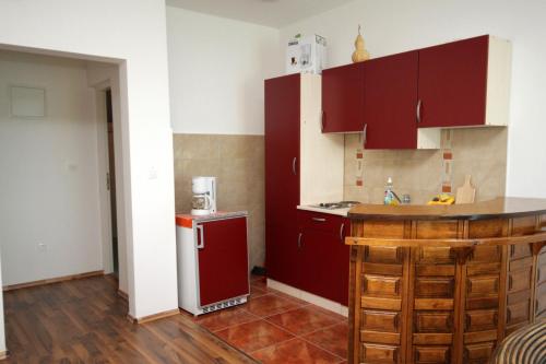 a kitchen with red cabinets and a red refrigerator at Apartments with a parking space Novi Vinodolski - 7503 in Novi Vinodolski