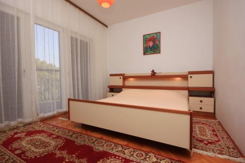 a bedroom with a bed and a large window at Holiday apartments Pjescana Uvala, Pula - 7652 in Pula