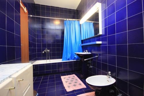 a blue tiled bathroom with a sink and a toilet at Holiday apartments Pjescana Uvala, Pula - 7652 in Pula