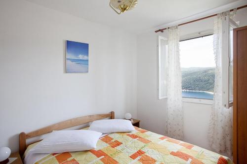 een slaapkamer met een bed en een raam bij Apartments with a parking space Rabac, Labin - 7622 in Rabac