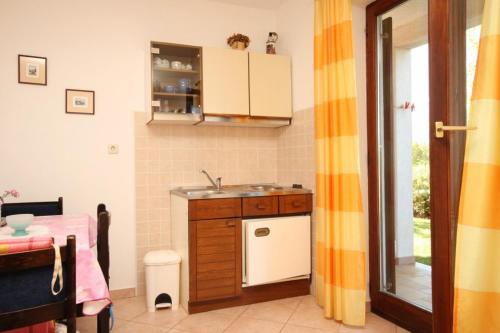 a small kitchen with a sink and a table at Apartments with a parking space Presika, Labin - 7617 in Labin