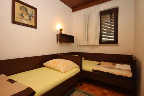 a room with two beds and a window at Apartments with a parking space Ravni, Labin - 7613 in Ravni