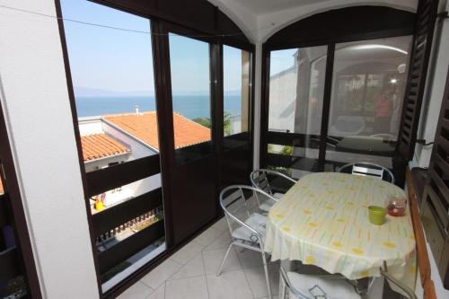 uma mesa e cadeiras numa varanda com vista para o oceano em Apartments with a parking space Ravni, Labin - 7613 em Ravni