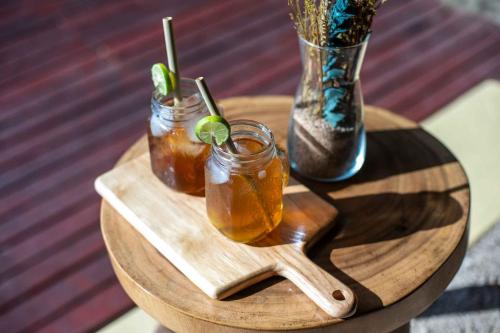 a wooden table with two drinks on a wooden tray at Catappa Village Lombok in Sekotong