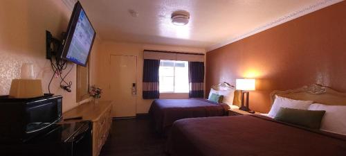 a hotel room with two beds and a flat screen tv at Lakeview Inn in Lucerne