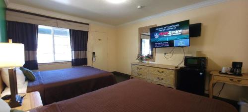 a hotel room with two beds and a flat screen tv at Lakeview Inn in Lucerne