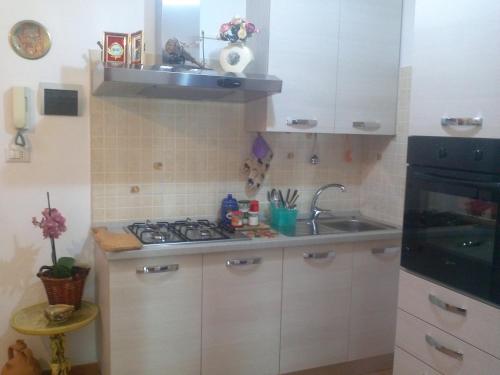 uma pequena cozinha com um lavatório e um fogão em Casetta "Anna" em Borgo Celano