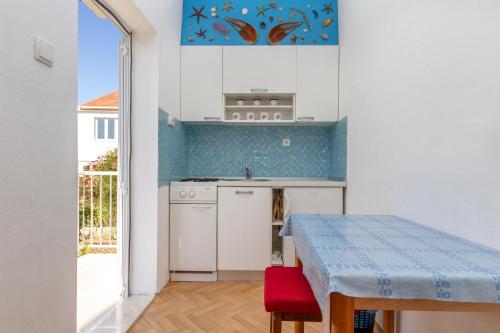 a kitchen with a table and a counter top at Apartments by the sea Seget Vranjica, Trogir - 5964 in Seget Vranjica