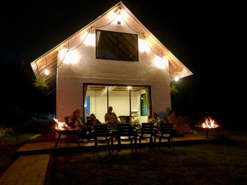 a group of people sitting in front of a house at night at TOSCANA de Tomine in Guatavita