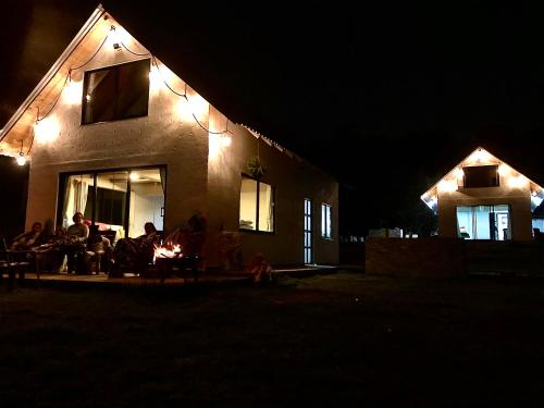 a group of people sitting around a fire at night at TOSCANA de Tomine in Guatavita