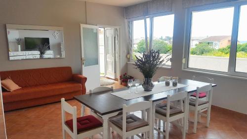 a living room with a table and chairs and a couch at Apartments with parking space Rab - 12383 in Rab