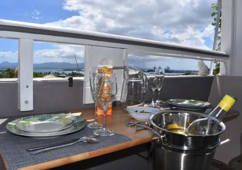 einen Tisch mit Tellern und Weingläsern auf dem Balkon in der Unterkunft Blue lagon appart in Le Gosier