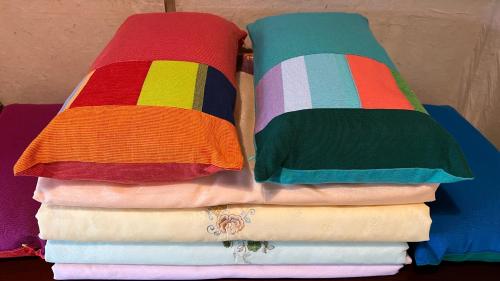 two stacks of colorful pillows on a pile of towels at Big Blue House in Boseong