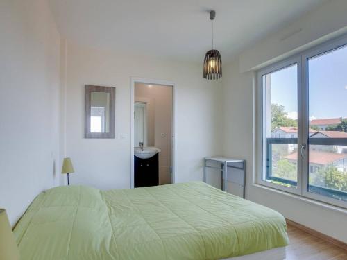 um quarto com uma cama verde e uma janela em Appartement Saint-Jean-de-Luz, 2 pièces, 4 personnes - FR-1-4-646 em Saint-Jean-de-Luz