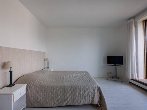 une chambre blanche avec un lit et une télévision dans l'établissement Studio confortable avec parking à Saint-Jean-de-Luz, proche plage - FR-1-4-650, à Saint-Jean-de-Luz