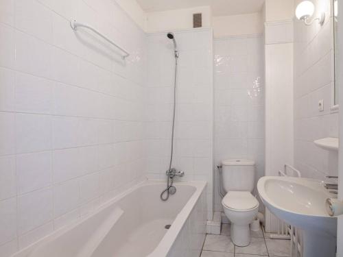 La salle de bains blanche est pourvue d'une baignoire, de toilettes et d'un lavabo. dans l'établissement Studio confortable avec parking à Saint-Jean-de-Luz, proche plage - FR-1-4-650, à Saint-Jean-de-Luz