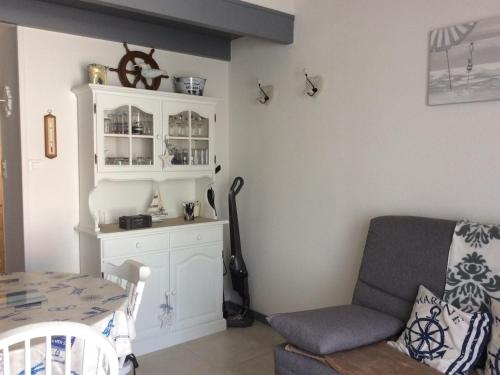 un salon avec une chaise et une table dans l'établissement Maisonnette près de la plage avec cour privée et parking, idéale pour 4 pers. et balades en bord de mer - FR-1-476-189, à La Faute-sur-Mer