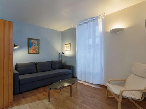 a living room with a blue couch and a chair at Studio moderne Ciboure, cœur historique, idéal pour couples - FR-1-4-657 in Ciboure