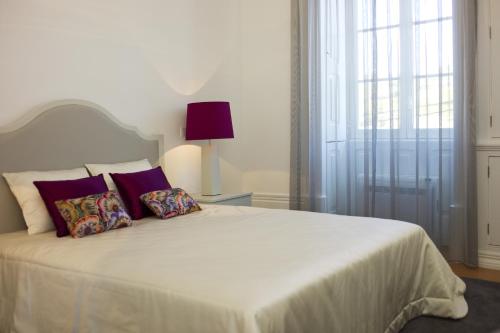 a bedroom with a white bed with two pillows at Casa de Cambres in Lamego