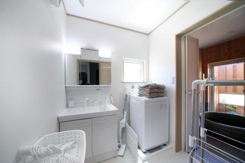 a white laundry room with a washer and dryer at 白浜貸別荘2-76 in Kanayama