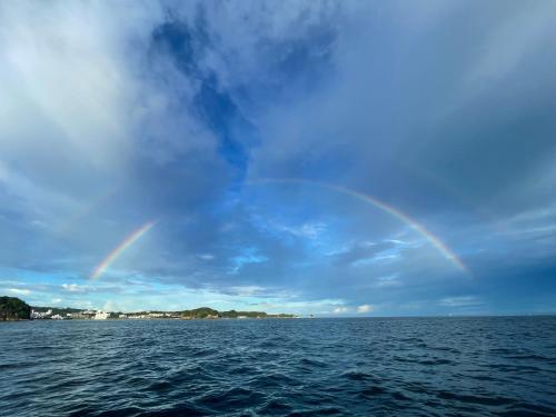 a rainbow in the sky over a body of water at 白浜貸別荘2-76 in Kanayama