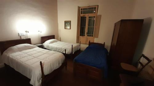 a room with two beds and a window at La Casona in Godoy Cruz