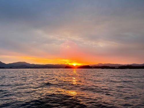 a sunset over a body of water at 白浜貸別荘2-76 in Kanayama