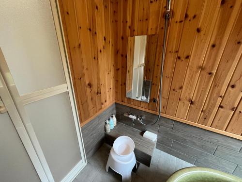 a bathroom with a toilet in a wooden wall at 白浜貸別荘2-76 in Kanayama