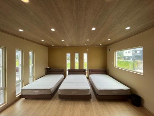 two beds in a room with two windows at 白浜貸別荘2-76 in Kanayama