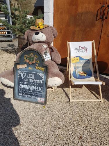 a teddy bear sitting in a chair next to a sign at Gästehaus zum Felsen in Überlingen