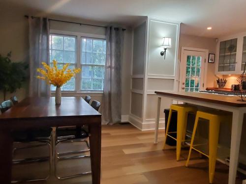 a kitchen with a table and yellow chairs in it at Cheerful 2 BR Near Colleges, Downtown, Attractions in Montgomery