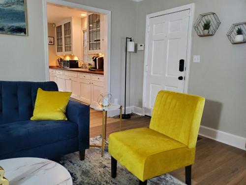 a living room with a blue couch and a yellow chair at Cheerful 2 BR Near Colleges, Downtown, Attractions in Montgomery