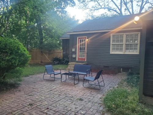 a patio with chairs and a table in front of a house at Cheerful 2 BR Near Colleges, Downtown, Attractions in Montgomery