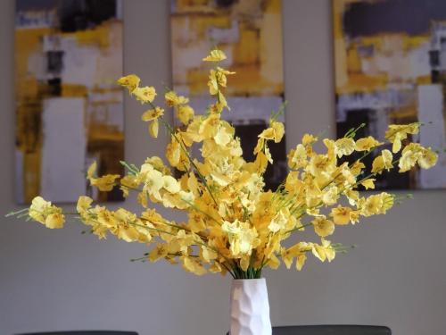 a vase filled with yellow flowers on a table at Cheerful 2 BR Near Colleges, Downtown, Attractions in Montgomery