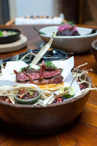 a bowl of food with meat and vegetables on a table at Casa 1810 Parque Hotel Boutique in San Miguel de Allende