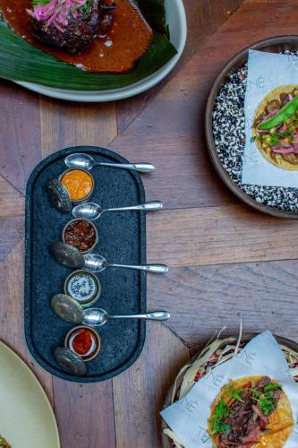 a table topped with plates of food and spoonsolitics at Casa 1810 Parque Hotel Boutique in San Miguel de Allende