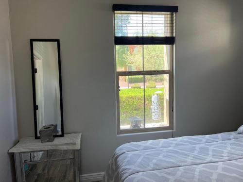 a bedroom with a bed and a mirror and a window at Queen creek az casita in Queen Creek